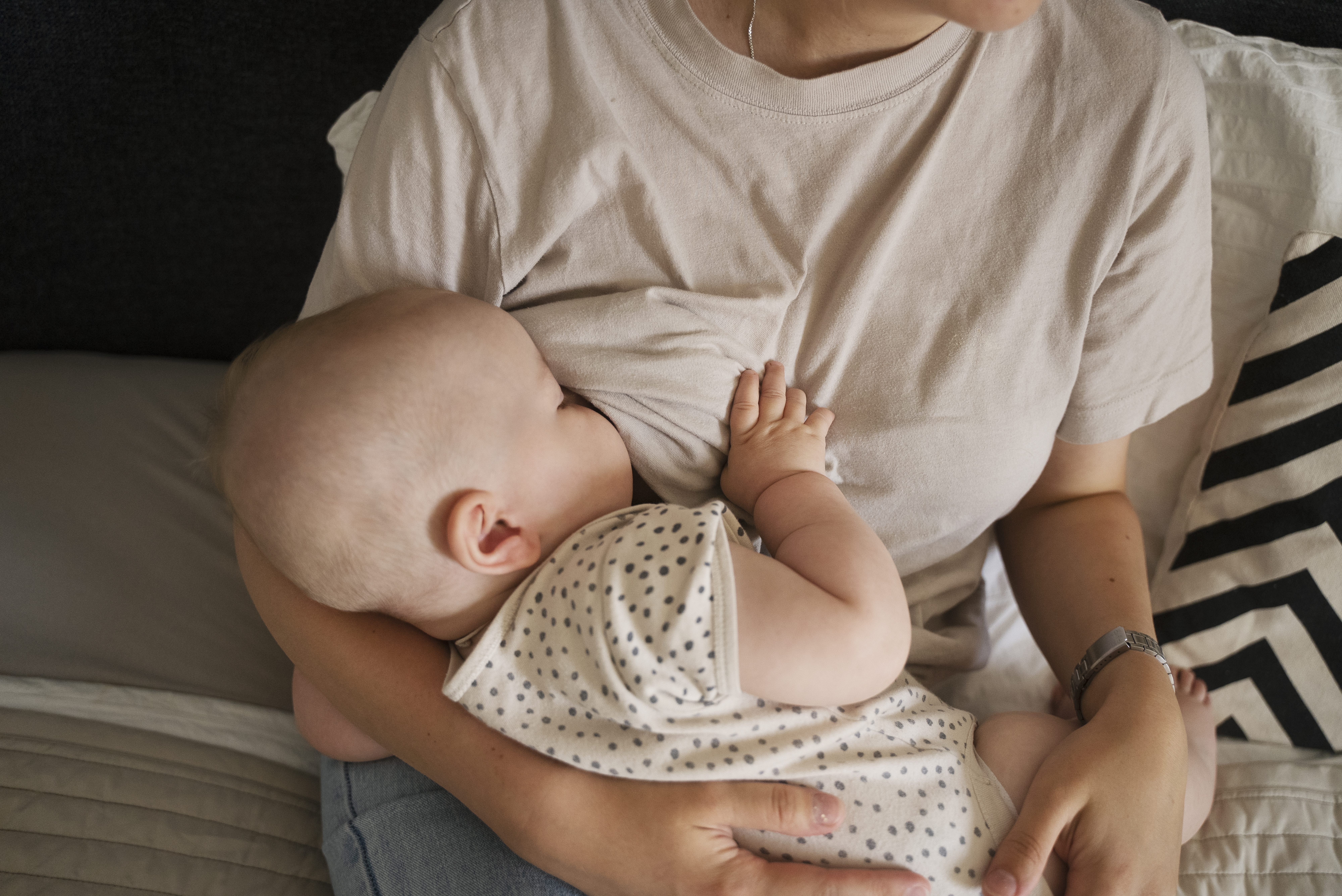 A mother breastfeeding indoors, viewed from above